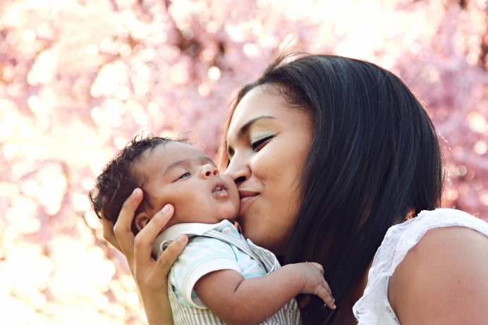 African American mom kissing baby son